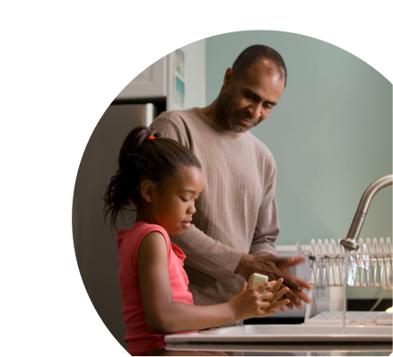 Dad helping daughter wash dishes